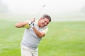 Golfer swinging his club on the course Royalty Free Stock Photo