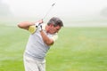 Golfer swinging his club on the course Royalty Free Stock Photo