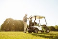 Golfer taking clubs from a bag in a golf cart Royalty Free Stock Photo