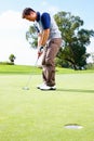 Golfer about to putt the ball. Full length of man playing golf and taking position to putt the ball in the hole. Royalty Free Stock Photo