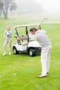 Golfer about to tee off with partner behind him Royalty Free Stock Photo