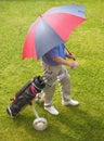 Golfer and umbrella Royalty Free Stock Photo