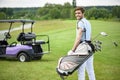 Golfer walking with golf bags Royalty Free Stock Photo