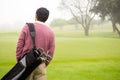 Golfer walking and holding his golf bags Royalty Free Stock Photo