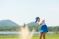 Golfer woman chip golf ball out of a sand trap. People swing and hitting golf course is on the fairway. Royalty Free Stock Photo