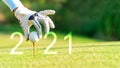 Golfer woman putting golf ball for Happy New Year 2021 on the green golf for new healthy. Royalty Free Stock Photo