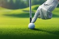 Golfers hand places ball on tee, lush green panorama Royalty Free Stock Photo