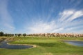 Golfers playing golf in Spain on a perfect summer day. Green surrounded by lakes Royalty Free Stock Photo