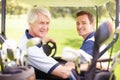 Golfing buddies. Golfing companions on the golf course in a golf cart. Royalty Free Stock Photo