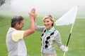 Golfing couple high fiving