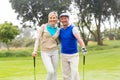 Golfing couple smiling at camera on the putting green Royalty Free Stock Photo