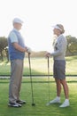 Golfing couple standing and talking Royalty Free Stock Photo