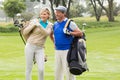 Golfing couple walking on the putting green Royalty Free Stock Photo