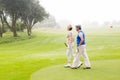 Golfing couple walking on the putting green Royalty Free Stock Photo