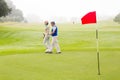 Golfing couple walking on the putting green Royalty Free Stock Photo