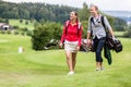 Golfing couple walking together on golf course Royalty Free Stock Photo
