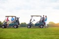 Golfing is fun for the whole family. two couples with golf carts spending a day on the golf course. Royalty Free Stock Photo