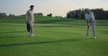 Golfing team play sport on course. Golf group practicing hits in country club.