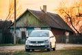 Volkswagen Polo Car Parking On Country Road On A Background Of Traditional Old Wooden Village House In Sunny Evening Royalty Free Stock Photo