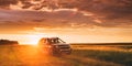 Renault Duster Or Dacia Duster Suv In Road Through Summer Wheat Field In Amazing Sunset Time.