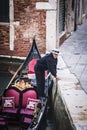 Gondola boat with its owner, in Venice (Italy)