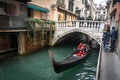 Gondola flows under the bridge at the narrow canal in Venice, Italy