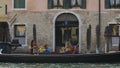 Gondola going down channel with passengers onboard and gondolier propelling it