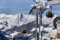 Gondola lift. Cabin of ski-lift in the ski resort in the early morning at dawn with mountain peak in the distance. Winter Royalty Free Stock Photo