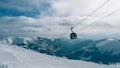 Gondola lift. Cabin of ski-lift in the ski resort Yasna at dawn with mountain peak in the distance. Winter snowboard and skiing