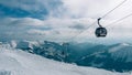 Gondola lift. Cabin of ski-lift in the ski resort Yasna at dawn with mountain peak in the distance. Winter snowboard and skiing