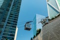 Gondola lift at Salesforce Transit Center carries tourists from street level to rooftop park. Millennium Tower in background. -