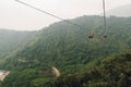 Gondola lifts moving over mountain with green trees in the area of Sun Moon Lake Ropeway in Yuchi Township, Nantou County, Taiwan