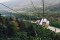 Gondola lifts moving from station over mountain with green trees in the area of Sun Moon Lake Ropeway in Yuchi Township.