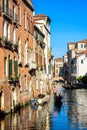 Gondola sails past vintage houses, Venice, Italy. Sunny view of old street in the Venice center