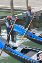 Man driving gondola boat in Venice, Italy