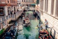 gondolas gracefully glide through narrow canals, weaving past vibrant, colorful houses, creating a captivating scene in the