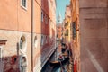 gondolas gracefully glide through narrow canals, weaving past vibrant, colorful houses, creating a captivating scene in the