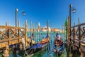 Gondolas moored docked at wooden pier in water of San Marco basin Royalty Free Stock Photo