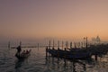 Gondolas on the river water overlooking Venice on a foggy day in Italy