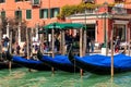 Gondolas tied to the wooden pillars on Grand Canal in Venice, Italy