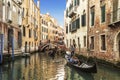 Gondolas with tourists sailing along a canal in Venice,