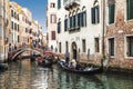 Gondolas with tourists sailing along a canal in Venice,