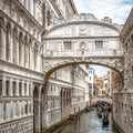 Gondolas with tourists sails on old canal under medieval Bridge of Sighs by Doge`s Palace, Venice Royalty Free Stock Photo