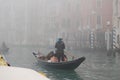 Gondolier carries tourists through the canals of Venice. Royalty Free Stock Photo