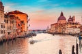 Gondolier carries tourists on gondola sunset Grand Canal of Venice, Italy Royalty Free Stock Photo