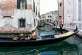 Gondolier carries a young couple of tourists in the small canals of Venice, Italy Royalty Free Stock Photo