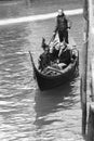 Gondolier carrying tourists in Venice, black and white Royalty Free Stock Photo