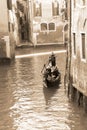 Gondolier carrying tourists in Venice, sepia tone