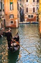 Gondolier is driving a gondola at narrow channel in Venice Royalty Free Stock Photo