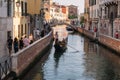 Gondolier is driving a gondola with a woman who playing the violin in Venice, Italy Royalty Free Stock Photo